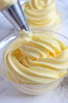 a bowl filled with yellow frosting on top of a table