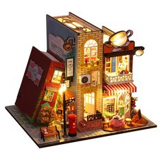 a doll house is lit up with lights and decorations on the front, side, and top floors