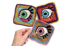 two crocheted square coasters with an eye on one side and the other