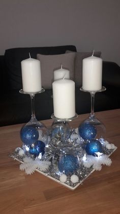 three candles sitting on top of a table with blue and white ornaments around it in front of a couch