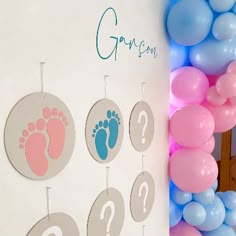 a baby's foot and footprints are on the wall next to balloon garlands