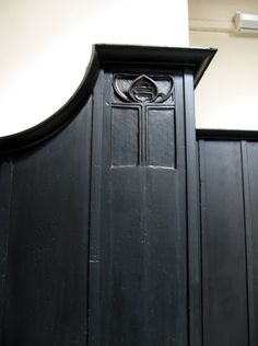 an old black wooden door with a cross on it's front and side panel