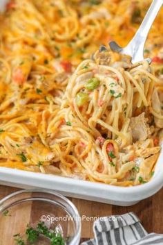 a large casserole dish filled with pasta and meat, garnished with parsley