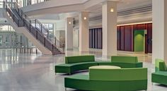 an empty lobby with green couches and stairs