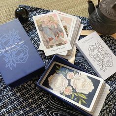 some cards are sitting on a table next to a teapot