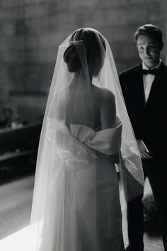 a man in a tuxedo standing next to a woman in a wedding dress