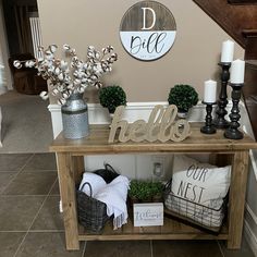 a wooden table topped with vases filled with flowers next to a stair case covered in decorative items