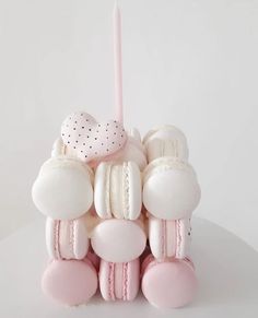 a pink and white sculpture made out of doughnuts with a candle in the middle