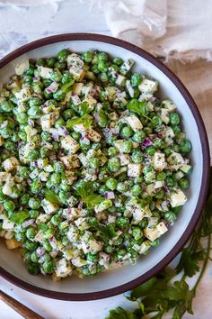 a white bowl filled with green vegetables on top of a table