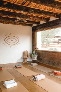 yoga mats are laid out on the floor in front of a window with an eye drawn on it