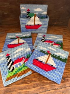 A set of needlepoint nautical coasters featuring sailboats and lighthouses. 6 coasters in holder. Needlepoint Coasters With Cording, Plastic Canvas Lighthouse Pattern, Needlepoint Coasters Plastic Canvas, Plastic Canvas Beach Patterns, Cruise Ship Cross Stitch Pattern, Needlepoint Coasters, Nautical Coasters, Fish Needlepoint, Canvas Coasters