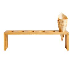 a wooden bench with four cups on it and one bowl sitting on the backrest