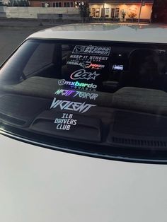 the back window of a white car with stickers on it's side windows