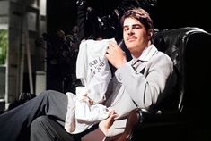 a man sitting in a chair holding a white shirt