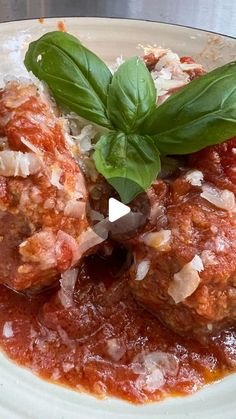 meatballs covered in marinara sauce and garnished with fresh basil on top