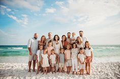 a group of people standing on top of a sandy beach