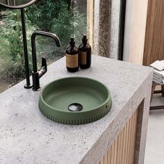 a green sink sitting on top of a counter next to a mirror and bottle opener