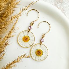 ～PRODUCT DETAILS * Hooks: stainless steel (nickel free and hypoallergenic) * Connector: cubic zirconia  * Pendant: brass frame, real pressed daisy flowers and clear resin * Earrings length: 6,1 cm/2,4" * Sold in pairs * You can choose the daisy color: - pink - white  * The colours may look slightly different due to the lighting when the pictures were taken ～SHIPPING * All orders will be shipped out within 1-2 business days via Italian registered mail  * You will receive the tracking number to tr Daisy Jewelry, Resin Flowers, Clear Resin, Brass Frame, How To Preserve Flowers, Daisy Flower, Flower Earrings, Daisy, Jewelry Earrings Dangle