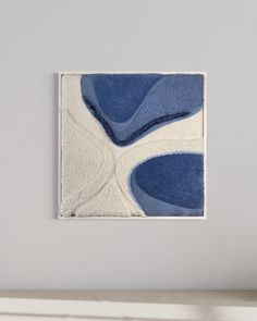 a blue and white painting hanging on the wall