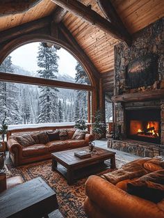 a living room filled with furniture and a fire place in front of a large window