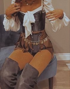 a woman sitting on top of a blue chair wearing tights and boots with her hands in her pockets