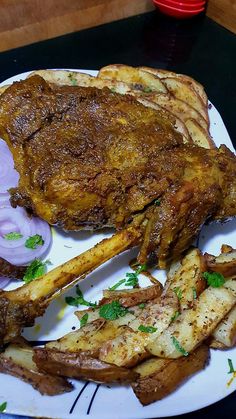 a white plate topped with meat and french fries