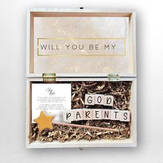 a box filled with wood chips and words that say, will you be my god parents?