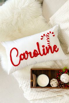 a white pillow with the word careline on it next to some candles and other items