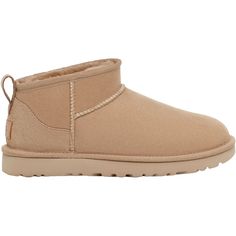 Stay warm and cozy in the cold months with these stylish boots. The UGG Classic Ultra Mini is a casual women's sheepskin ankle boot with a lower shaft height, adding easy on-off and enhanced versatility. These UGG Classic Ultra Mini Sand Sheepskin Women's Boots have the following features: 17mm Twinface sheepskin upper Post-Applied Treatment Treated to repel light amounts of water. The product should be re-treated periodically to maintain protection Asymmetrical topline, Overlock stitch detailin Ugg Ultra Mini, Ugg Classic Ultra Mini, Stylish Boots, Flip Flop Shoes, Ugg Classic, Trail Shoes, Suede Heels, Womens Uggs, Ankle Strap Sandals