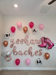 a room with balloons, cowgirl boots and the words yeehaw baches