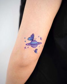 a woman's arm with a purple butterfly tattoo on the left side of her arm