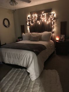 a bedroom with lights on the headboard and bed in it's centerpiece