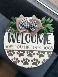 a dog door hanger with a bow on it that says welcome hope you like our dogs