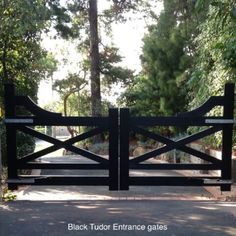 a black gate that is next to some trees