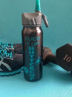 a water bottle next to a pair of running shoes on a blue mat with the words suki it up