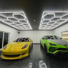 two yellow and green sports cars are parked in a room with lights on the ceiling