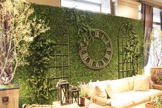 a living room filled with lots of furniture and greenery on the wall behind it