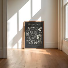 there is a poster on the floor in front of a window that reads herbeology