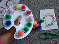 a child's hand is pointing at some cupcakes on a paper plate