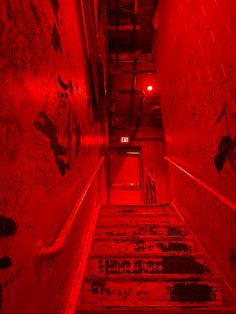 the stairs are covered with graffiti and red light is shining in the room above them