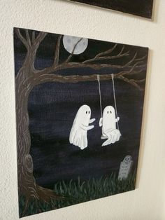 two ghost paintings hanging on the wall in front of a black and white background with trees