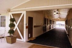 the inside of a horse barn with doors open