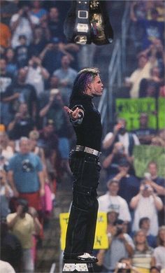 a man standing on top of a metal object in front of a crowd