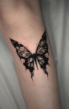 a black and white butterfly tattoo on the arm