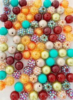 many different colored beads on a white surface