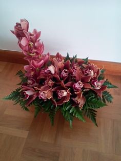 a bouquet of pink flowers sitting on top of a wooden floor