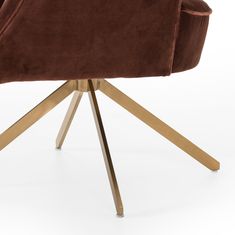 a brown velvet chair with gold legs on a white background