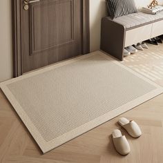 a pair of slippers sitting on top of a rug next to a wooden door