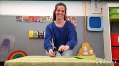 a woman sitting at a table with scissors in her hands