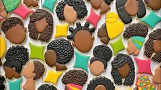 cookies decorated with different types of women's hair are displayed on a white surface